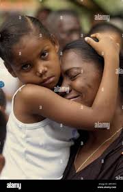 Dominican Felicita Pena is consoled by her daughter Hianna during a mass in  honor of the flood victims ofthe Dominican Republic and Haiti, in Jimani,  Dominican Republic, about 200 kilometers (124 miles)