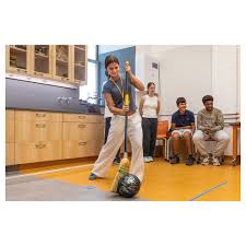 In Matt Dilley's Grade 9 Physics class, students participated in a bowling  ball and broom relay race yesterday. Using broom bristles, they guided a  bowling ball across the floor of their Annex