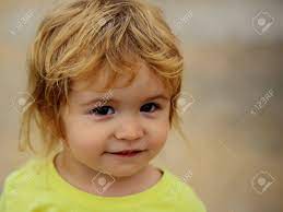 Cute Baby Boy Child With Curly Blond Curly Hair In Yellow Shirt And Brown Eyes Outdoor On Blurred Background Close Up Stock Photo Picture And Royalty Free Image Image 65082642