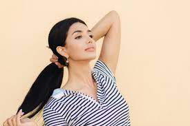 foto lateral de uma mulher morena bonita mantém o cabelo no rabo ...