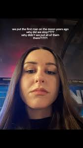 sophie carrying shit: “the moon landing was fake” sign, drink, tape