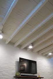 Cozy Chic Basement Reno With Exposed Painted Joists Wood Tile Floors Basement Makeover Basement Lighting Basement Design