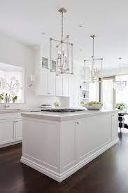 A White Kitchen Island Boasting A Light Gray Quartz Countertop Is Fitted With An Integrated Gas White Kitchen Island Transitional Kitchen Design Kitchen Design