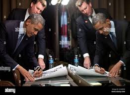 Trip Director Marvin Nicholson watches as President Barack Obama signs  items after delivering remarks at the LGBT Leadership Council Gala in  Beverly Hills, Calif., June 6, 2012 Stock Photo