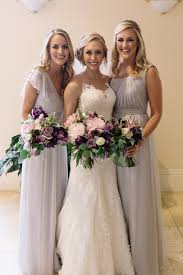 Bride And Her Bridesmaids In Pale Grey Gowns Carry Their Bouquets Of Light Pink Peony Ocean So Light Purple Wedding Purple Wedding Flowers Dark Purple Wedding