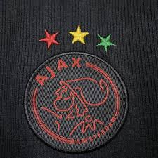 The shirt has a black base colour with green, yellow and red adidas stripes on the shoulders whilst the cuffs are also made up of the same three colours. Camisa Ajax Iii Bob Marley 2021 Torcedor Masculina Asah Sports