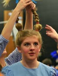 Senior Emma Goode allows other cast members to rearrange her pigtails.  Photo by Libby Wilson