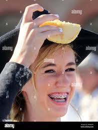 Emylee Bratton picks a pancake off her cowboy hat after missing the toss  during the annual Cheyenne Frontier Days free pancake breakfast sponsored  by the Kiwanis Club of Cheyenne at the Cheyenne