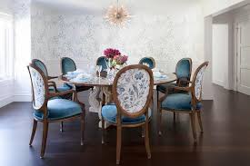 An Elegant Blue And White Dining Room Features A Arteriors Zanadoo Chandelier Hung Above A Round Fre Dining Chairs Dining Room Wainscoting French Dining Chairs