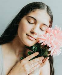 Une femme tenant une fleur rose dans ses mains photo