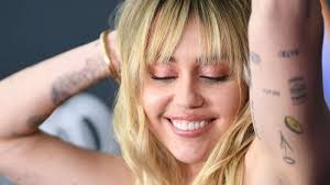 On the sides of her fingers are an equal sign, a peace symbol, a cross, bad from the michael jackson album, and the word karma. on her knuckles she has a heart, an evil eye, an alien head, and a watermelon slice. Miley Cyrus Shows Off New Freedom Tattoo Gma