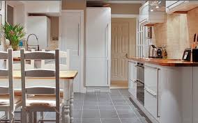 Modern kitchen with grey wall tiles, black worktop, sink and tap. Case Studies Of Kitchen Installations By Black Rok