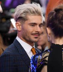 Via Fashionbeanscom Zac Efron May Just Be The Only Man On The Planet Brave Enough To Attempt A Bleached Messy Under Zac Efron Hair Zac Efron Mens Hairstyles