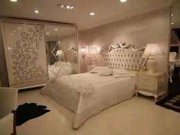 غرفه نوم تركي باللون الأبيض مكونة من سرير مبطن ودولاب جرار منقوش بمرايا مع عدد 2 كومودينو بأدراج بتصميم عصرى فريد لدى محل جاليرى جودى