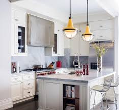 White kitchen with stacked wall cabinets, custom range hood, and large island with plenty of seating. Off White Kitchen Cabinets With Gray Marble Slab Backsplash Transitional Kitchen