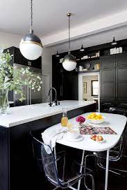 When imagining the dream kitchen, that dream for many will include a central kitchen island. White Oval Dining Table In Front Of Black Kitchen Island Transitional Kitchen