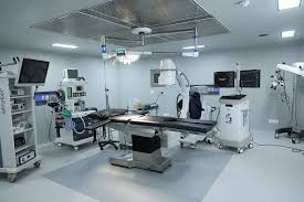 Modern operating theatre with surgical table, C-arm imaging, monitors, and equipment