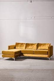 Yellow and gray sunroom features a charcoal gray sofa lined with yellow and gray pillows facing a pair of mustard yellow velvet chairs across from a round yellow and gray floral tufted ottoman placed before a stone fireplace. 10 Mustard Yellow Sofas For A Mid Century Modern Vibe Velvet Sectional Yellow Sofa Sectional Sofa