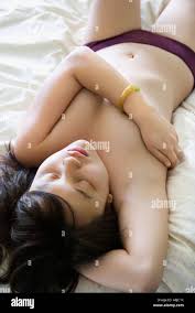 Portrait of partially nude pretty young Asian woman lying in bed with eyes  closed Stock Photo - Alamy