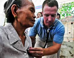 Lt. Cmdr. Marion Gregg listens to the lungs of a Vietnamese