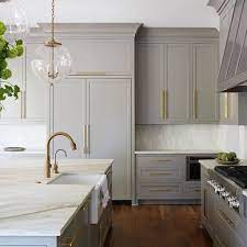 Silver handles and appliances integrate seamlessly into the system. I Love These Light Gray Cabinets With Gold Handles Painting Kitchen Cabinets New Kitchen Cabinets Modern Kitchen Cabinets