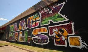 People walk by a mural for black wall street in the greenwood district on may 30. Visitors To Tulsa S Greenwood District Left To Wonder What Could Have Been
