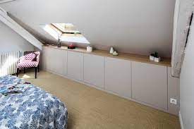 Dressing sous pente blanc avec multitude de rangements et ceintes pour chemises et vestes. Placard Amenage Sous Les Toits Blanc Avec Une Etagere En Bois