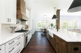 White cabinets with marble counter top, dark island with white marble countertop, medium hardwood flooring. Daniel Island Drive Farmhouse Kitchen Charleston By Delpino Custom Homes Houzz