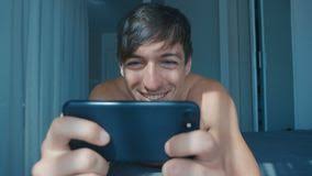 Elle voit un petit chien qui s'est perdu. Jeune Homme Nu Concentre Jouant Le Jeu Sur Le Portable Tout En Se Retrouvent Aussi Bien Dans Le Lit A La Maison Clips Videos Video Du Medias Utilisation 167574215