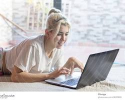 person smiling and relaxed while working on their laptop resmi