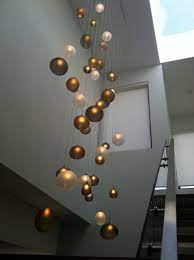 Crafted from metal, it features a circular ceiling mount, a hanging chain, and six lights sticking out from rods at all angles for a modern and linear look. High Ceiling Lighting Houzz
