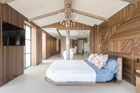 The room has a stone wall and a large stone fireplace, along with a large cozy bed. 75 Beautiful Bedroom With Brown Walls Pictures Ideas July 2021 Houzz