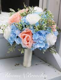 A pastel spring wedding bouquet in ivory and soft yellows plus lily of the valley and a simple wrap. Wedding Bouquet Wedding Flowers Blue Peach Ivory Bouquets Hydrangea Bridal Bouquet Flowers For Destination Wedding Hydrangeas Roses Blue Wedding Flowers Wedding Flowers Bridal Bouquets Wedding Flowers