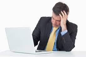 الرجل في محنة يجلس على المكتب بينما يستخدم Laptop صورة الخلفية والصورة  للتنزيل المجاني - Pngtree