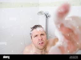A young caucasian man takes a shower and notices a hidden camera Stock  Photo - Alamy