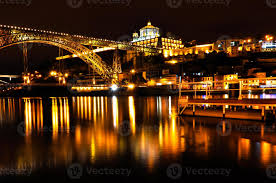 Under the 6 bridges of porto, board one of the typical rabelo barcos, which in the past were used to transport port wine. Bridge Across The River In Porto By Night 1403989 Stock Photo