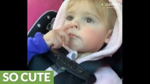Little girl adorably determined to pick her nose