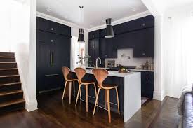 There are lots of contrasting finishes going on in this transitional kitchen—hardwood floors, a natural stone accent wall, dark grey cabinets and a waterfall marble island contribute to the unique rustic design. Dark Wood Kitchen Floor Ideas And Inspiration Hunker