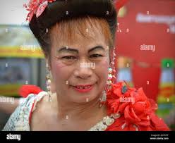 Middle aged dressed up Thai cross-dressing gender queer (kathoey) smiles  for the camera in Chinatown during Chinese New Year Stock Photo - Alamy