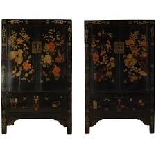 A truly distinctive setting to display your most cherished possessions, this black lacquer china cabinet's doors, top, and side panels are hand painted with an elegant, raised ''chinois'' scenery in a traditional landscape design. Pair Of 19th Century Chinese Black Lacquer Cabinet With Wucai Painting Chinese Furniture Chinoiserie Furniture Lacquered Cabinets