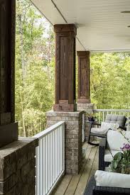 A brick home painted a dark brown comes alive with charming pale blue shutters and doors. Brick And Wood Columns Brick And Stained Wood Porch Columns Brick And Wood Columns Brick And Stained Wood Porch Porch Design Brick Columns House With Porch