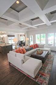 Living room furnished with a brick fireplace and neutral furnishings under a sloped ceiling with blond wood beams to accent. Pin On Living Room