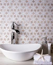 The ceramic floor tiles done in a herringbone pattern complement the marble sink & wall tiles. The Top Bathroom Tile Trends For 2021