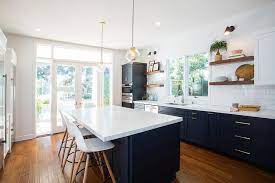 A blue kitchen set with a white countertop is the ideal combination to create a modern and sophisticated look to the kitchen. Navy Blue Kitchen Cabinets With Brushed Brass Pulls And White Marble Like Countertops Contemporary Kitchen