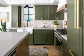 Green Shaker Cabinets Accented With Brass Hardware Flank A Window Framed By Cream Picket Green Kitchen Furniture Kitchen Decor Inspiration Olive Green Kitchen