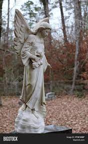 Typically a separate statue, it sits on top of a headstone, but oftentimes can be found as part of it as well. Angel Statue On Image Photo Free Trial Bigstock