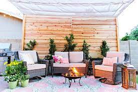 A weathered corner wood seating with white cushions and pillows. Pin On Patio Style Challenge