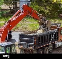 Truck with excavator loading for removal of waste building ...