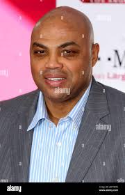 Former NBA player Charles Barkley, center, watches West Virginia and Auburn  from the sideline during the first half of an NCAA college basketball game 