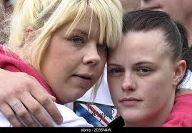 Cheryl Edgar (right), girlfriend of Sapper Daryn Roy, 28, and an unnamed  girl watch as hearses containing the coffins of Sapper Daryn Roy, Lance  Corporal Barry Buxton and Corporal Harvey Holmes pass through the town of  Wootton Bassett after their ...